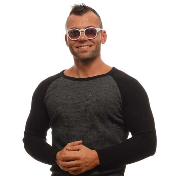 Homme souriant en pull et lunettes de soleil.