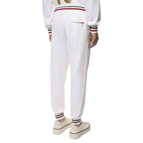 Pantalon blanc avec détails colorés aux chevilles.