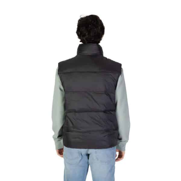 Homme de dos portant un gilet noir